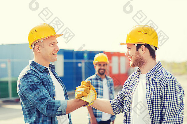 一群戴着安全帽的微笑建筑工人