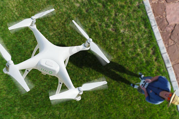 无人机（UAV）在飞行员上方的空中，带有遥控器。