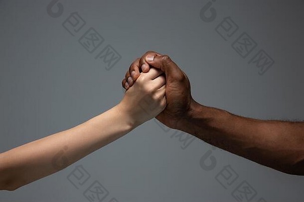 支持帮助种族宽容尊重社会团结非洲高加索人手手势灰色的工作室背景人类权利友谊和国际团结概念跨种族团结