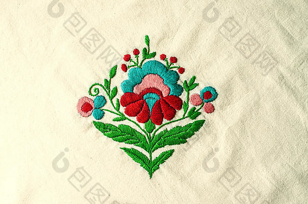 花束上的刺绣图案，棉织品上有红色、绿松石色和绿色的叶子