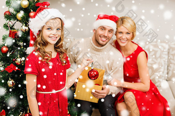 微笑的一家人在家里装饰<strong>圣诞</strong>树