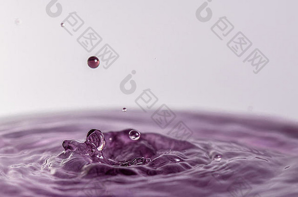 关闭宏摄影紫色的水下降溅水光彩色的白色灰色的背景