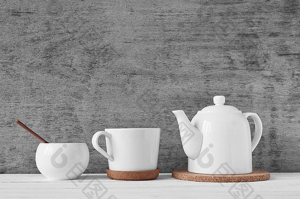 灰色背景上的一杯茶、茶壶和糖碗
