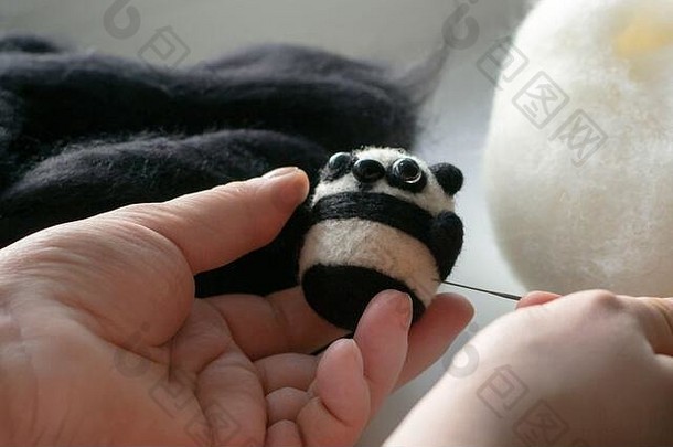 用白色和黑色的羊毛毡做一只小熊猫玩具的过程