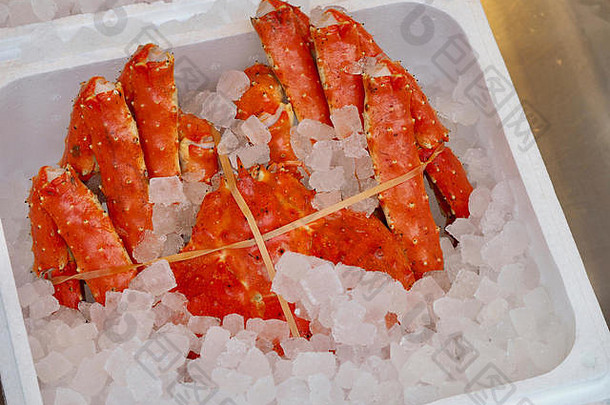 在日本北海道札幌的鱼市场上，用一盒冰将整个红帝王蟹煮熟出售