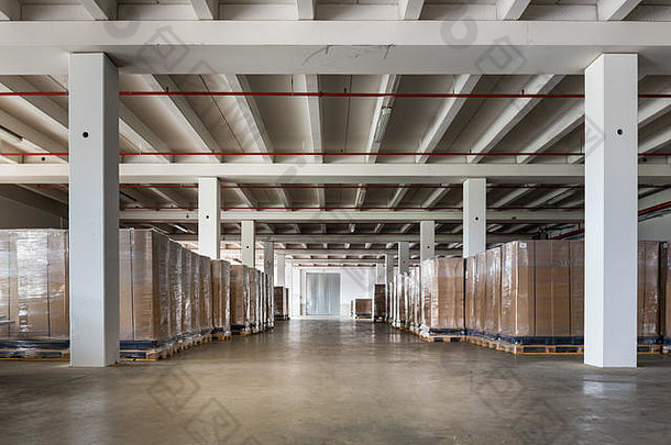 仓库有混凝土地板，包装好的纸箱整齐地堆放在托盘上。