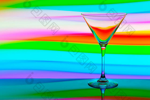 一个鸡尾酒/马提尼酒杯，酒杯后面有彩虹般的五彩光画