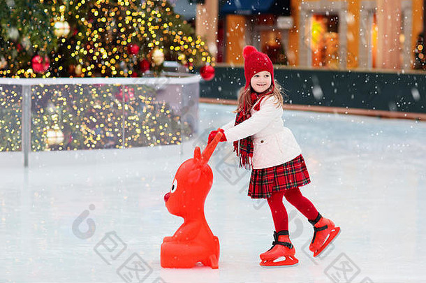 孩子们冰滑冰冬天公园溜冰场孩子们冰滑冰圣诞节公平女孩溜冰鞋冷一天雪户外有趣的孩子冬天