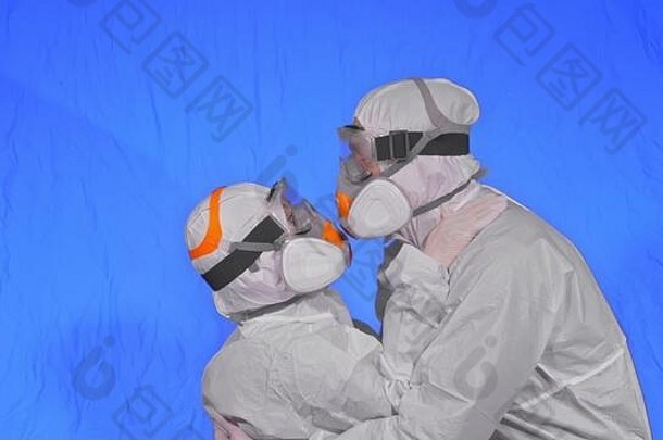 身穿防护服、防毒医用喷漆面罩的男女医生。双亲亲吻拥抱，呼吸器CVID-19中的健康工作者。