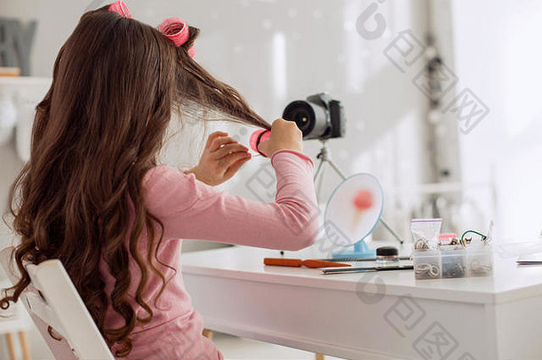 展示如何正确使用卷发器的学龄前女孩