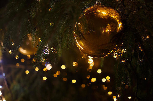 装饰圣诞树特写。金球和手电筒照明的花环。与博克的新年深色微距照片。寒假轻十二月