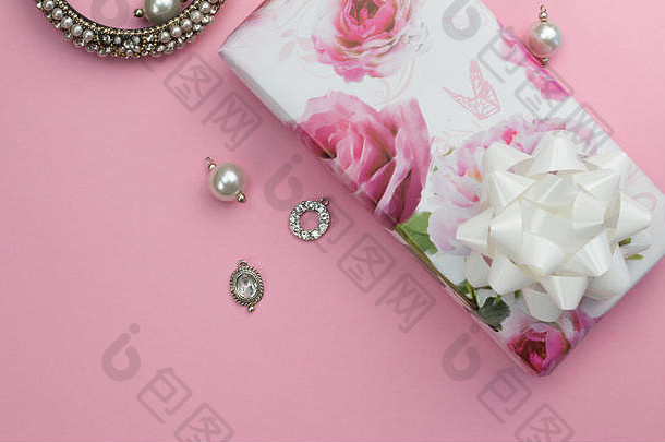 庆典粉色背景，孤立的玫瑰礼品包装礼物，珍珠手镯和项链吊坠头顶照片