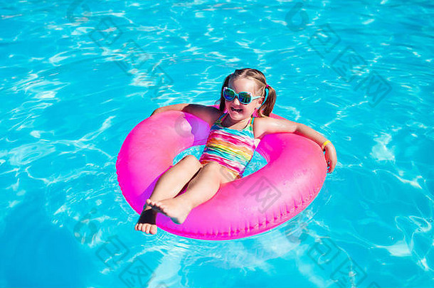 快乐女孩玩色彩斑斓的充气环户外游泳池热夏天一天孩子们学习游泳