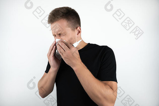 英俊的年轻病人擤鼻涕，用鼻喷雾剂喷在孤立的白色背景上