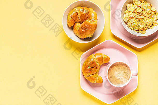 早餐咖啡和牛角面包，黄色背景，俯视图，平放。