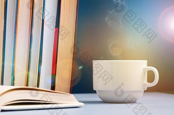 放在桌子上的咖啡杯或茶杯，上面放着一堆书和每日计划书或抄写本。作家和商业工作日