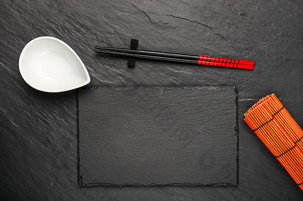 两个筷子和白色碗，黑色石头背景，带有文字空间，俯视图
