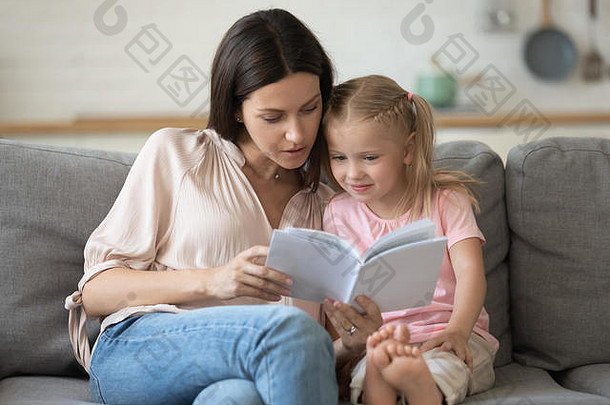 妈妈。女儿坐着沙发上<strong>阅读</strong>书