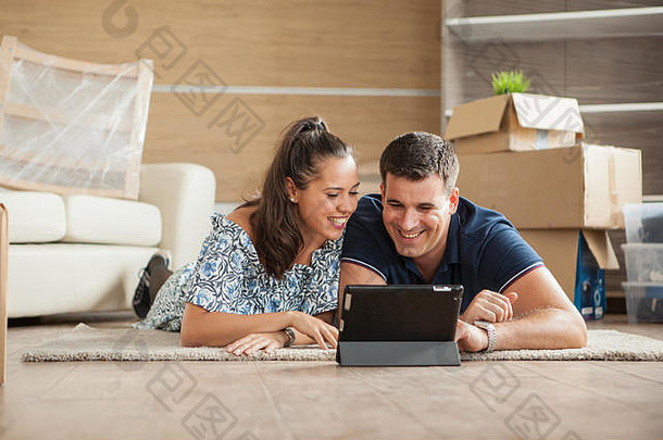 这对刚搬入<strong>新居</strong>的夫妇正在通过平板电脑在线购买家具