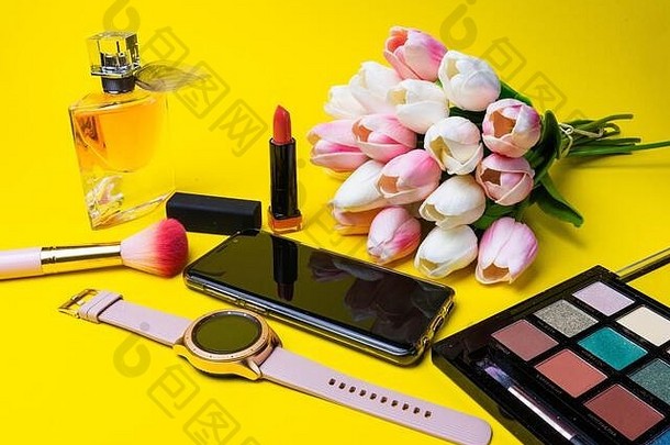 化妆产品香水刷花时钟移动电话多彩色的调色板黄色的背景