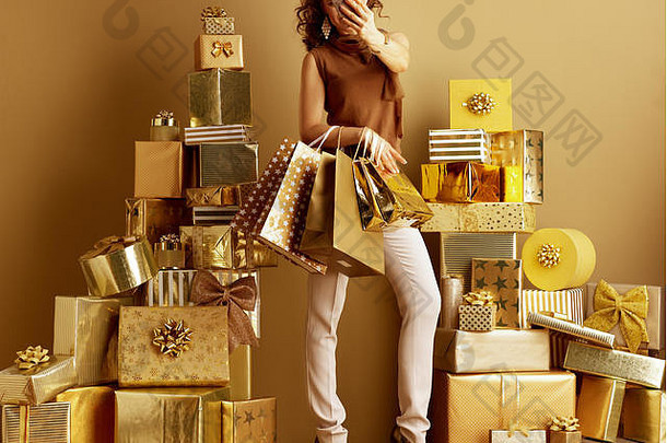 年轻的女人黄金米色裤子棕色（的）上衣购物袋采取自拍手机桩金礼物前面平原细胞膜
