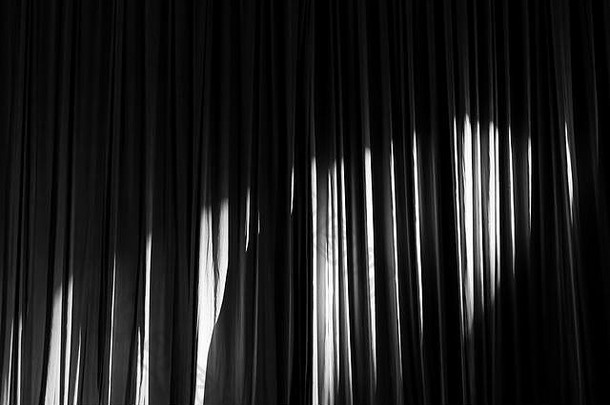 黑白窗帘和聚光灯在剧院的表演之间。