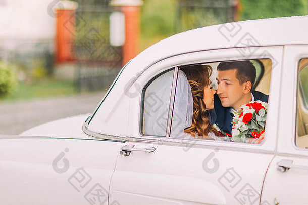 快乐新婚夫妇接吻后座古董车