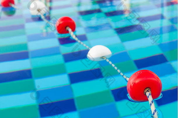 红色和白色的塑料漂浮在绳子上，游泳池里的边界