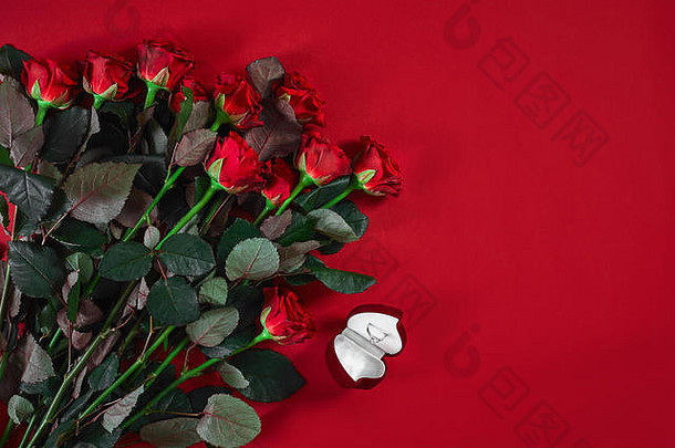 一束红玫瑰和一盒戒指。俯视图