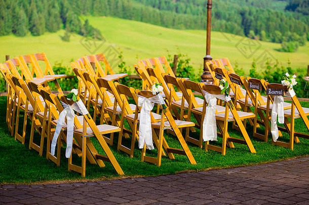 这个<strong>婚礼</strong>场地的椅子是木制的，看起来像是客人的优雅<strong>座位</strong>。
