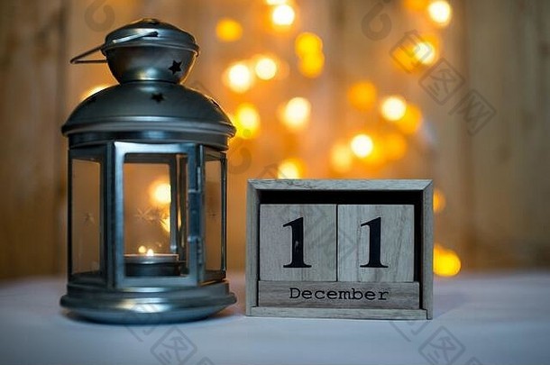 立方体木制日历，显示12月11日的日期，在博基背景上有降临灯笼。降临节日历、圣诞节背景、空间