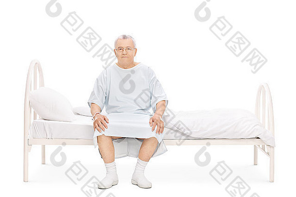 穿着医院长袍的成年患者坐在床上，看着隔离在白色背景上的摄像机