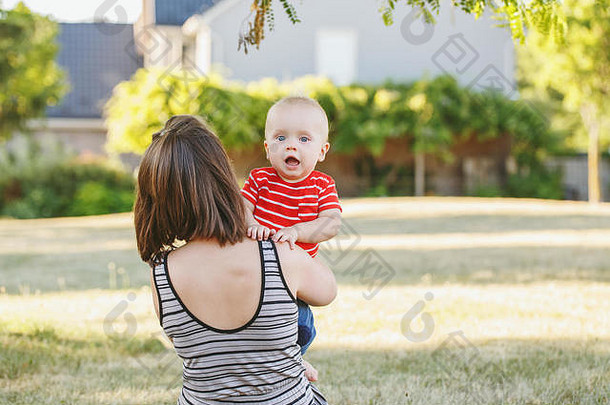 集团肖像高加索人妈妈。婴儿男孩红色的t恤场草地女父持有快乐微笑儿子孩子数目