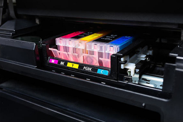 彩色打印机中CMYK墨盒的特写镜头。