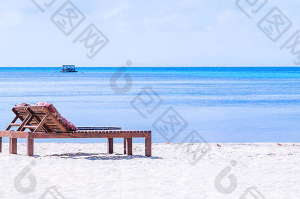 在蔚蓝的天空下，在海边美丽的沙滩上坐着椅子。<strong>暑期</strong>休闲的概念是一种<strong>旅游</strong>度假的理念。空拷贝空间