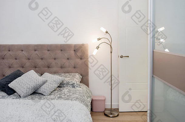 床的特写镜头，彩色枕头、床罩和舒适的台灯。阁楼内部，简约的斯堪的纳维亚风格。