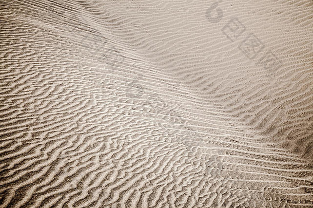 沙丘表面的沙和风模式。图案由两种类型的沙粒组成-深色、小而轻和大而轻和重