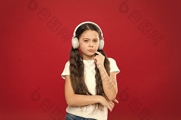 音乐对青少年的情感、感知世界有着强大的影响。女孩戴着红色背景的耳机听音乐。播放列表概念。音乐品味。音乐在青少年的生活中起着重要的作用。