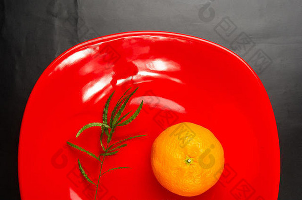 红色盘子里的<strong>橘子</strong>，黑色背景