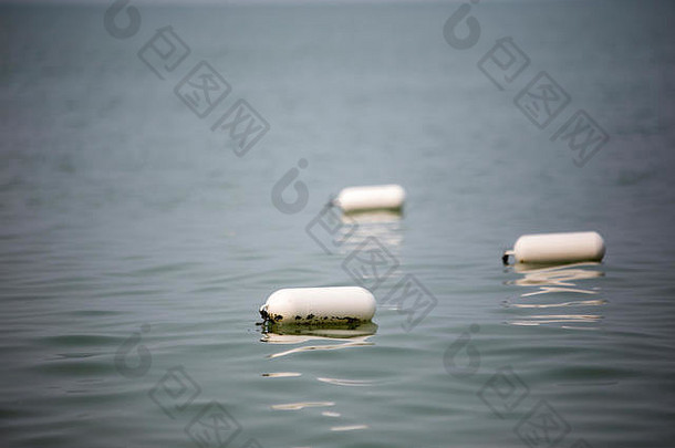 白色油缸形状的浮动标记浮动海水表面