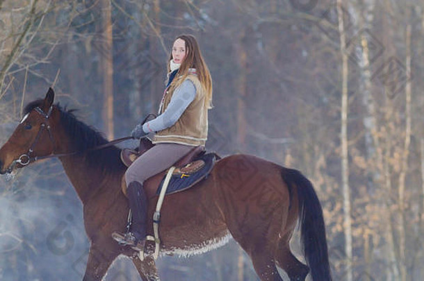 长毛女骑手在雪地里骑着一匹野马和一匹骑得很快的黑马