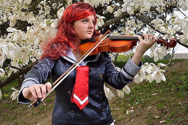 十几岁的女孩玩小提琴开花花园穿<strong>动漫</strong>服装假发