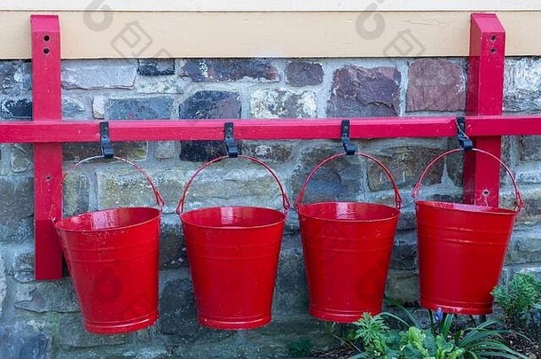 墙上挂着四个红色的水桶。也许是背景音乐。
