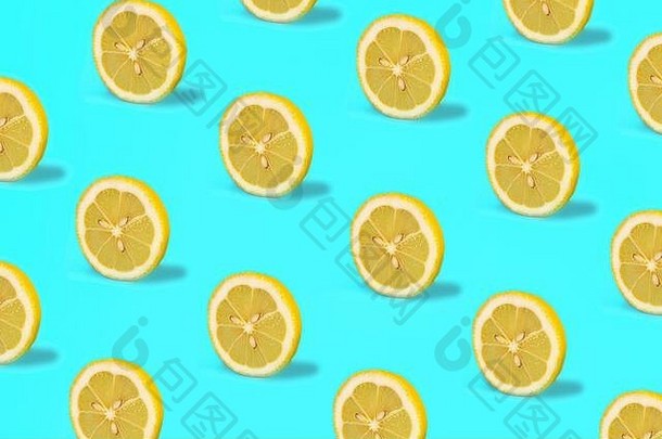 用柠檬水果做成的图案。绿色薄荷色背景上的热带抽象柠檬柑橘轮。时尚的夏季款式。简约时尚理念。平躺，近距离。