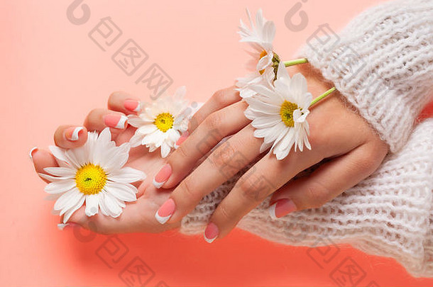 纤细年轻的双手捧着鲜花，手腕纤细，皮肤洁净，法式修指甲。平放照片，文字位置。