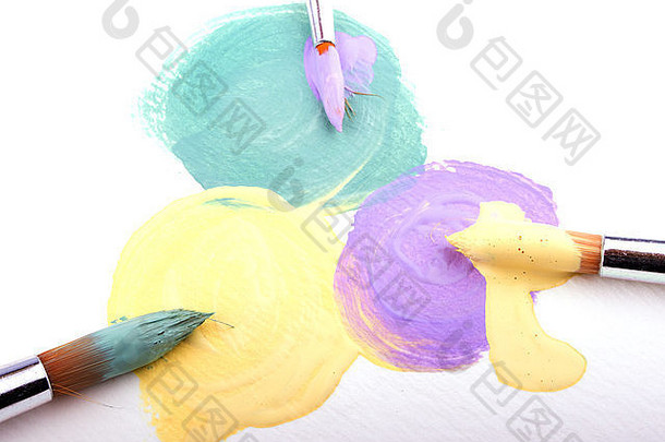 白色纹理纸上的绿色、黄色和淡紫色油漆斑点，每<strong>一点</strong>上<strong>都</strong>有<strong>不</strong>同颜色的画笔