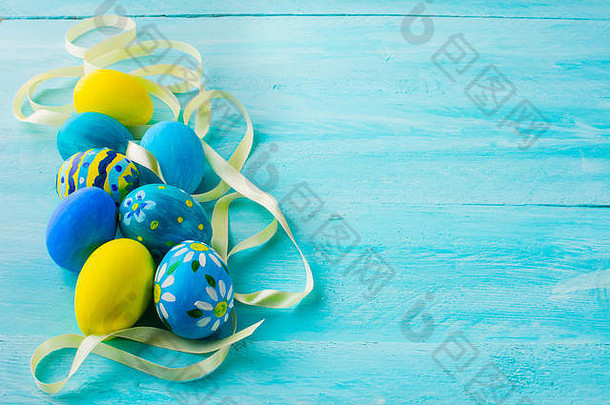 行蓝色的手绘复活节鸡蛋缎丝带蓝色的木板材复活节背景复活节象征前视图复制