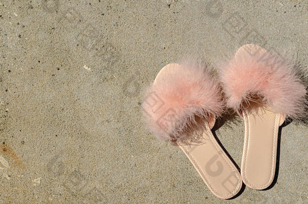 优雅的粉红色的羽毛拖鞋石头地板上户外