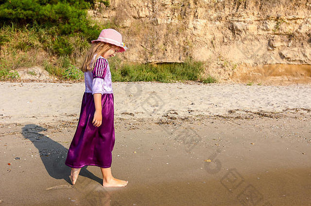 年轻的女人孩子他可爱的夏天衣服走海海岸浅水