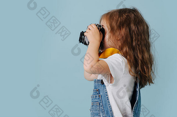 蹒跚学步的女孩使照片复古的相机